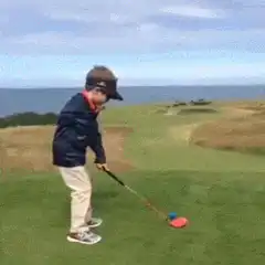 Toddler swings golf club on course