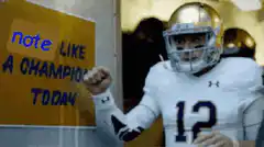 Football player points to note sign
