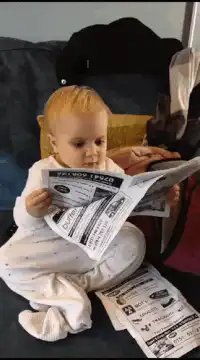 baby reading newspaper