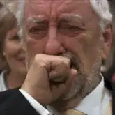 Old man crying with hand over mouth
