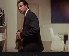 John Travolta holding coat and looking around