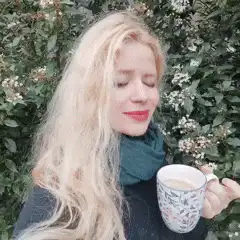 blonde woman sipping tea outside