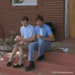 Two men eating on steps then riding a bike