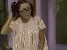 Girl in pigtails and glasses dancing excitedly