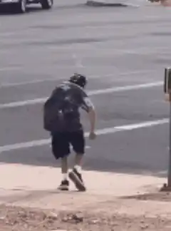 Man dancing on sidewalk near street