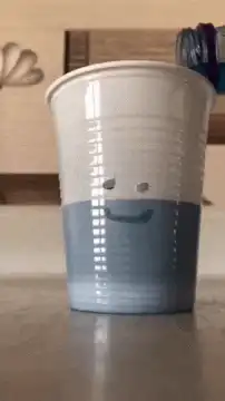 sad plastic cup leaking blue liquid
