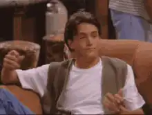 Joey Tribbiani shrugging on Friends couch