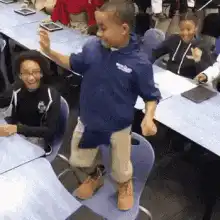 Dancing boy on chair in classroom