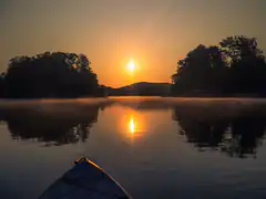 kayak on misty lake at sunrise