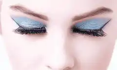 Woman opening eyes with blue eyeshadow