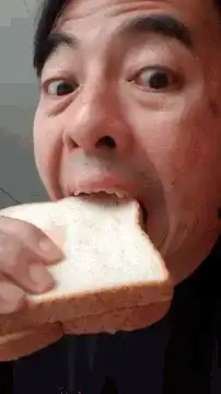 Man eating bread with wide eyes