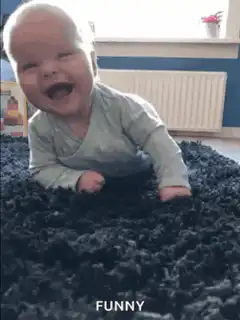 Baby laughing and rolling on rug