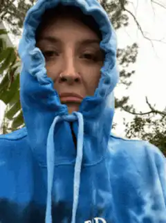 Woman in blue hoodie looking at camera