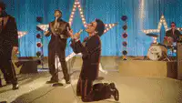 Elvis Presley kneeling on stage