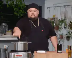 Chef tastes food from pot
