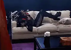 man on couch kicks pillow