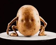 Potato with legs sitting on mashed potatoes