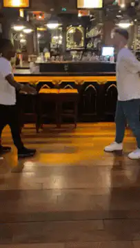 Two men doing a handshake dance