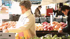 Woman holding cucumber at market