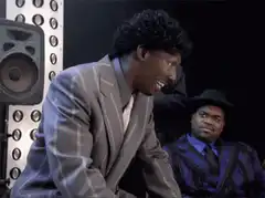 Man in grey suit laughing hysterically