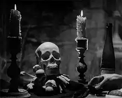 Hand pours drink for a skull