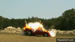 Red car exploding in a field