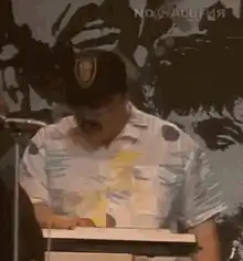Man in hat and sunglasses at podium