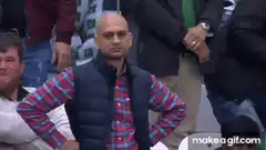 Man in plaid shirt and vest looking annoyed