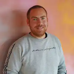 Man in grey sweatshirt smiling