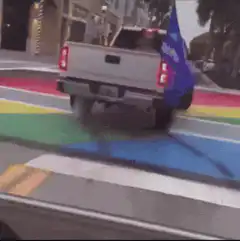 White truck doing a burnout on rainbow crosswalk