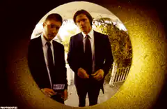 Two men in suits viewed through peephole