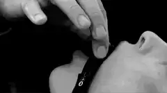 Hand touching face and removing collar