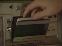 Hand inserts cassette into boombox