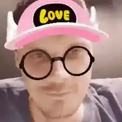 Man with pink love hat and round glasses