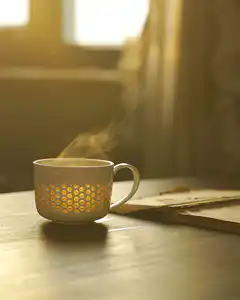 Steaming mug with glowing smiley faces
