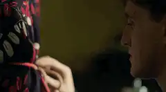 Man tying a red rope on a patterned dress