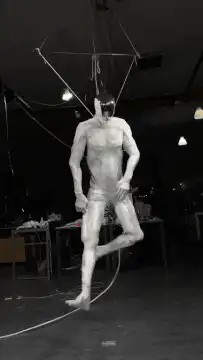 Muscular man suspended by wires