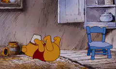 Winnie the Pooh lying on back drinking honey