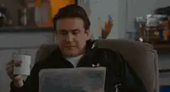 Chandler reads newspaper and reacts with shock