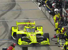 IndyCar pit stop with crew changing tires