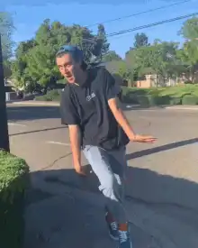 Man doing the running man dance on sidewalk