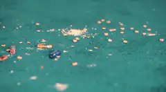 Pills and ash on green carpet