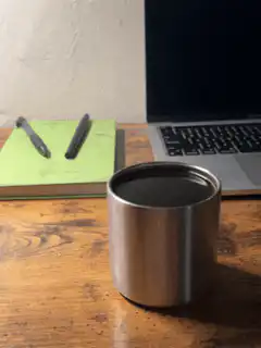 Metal cup on wooden desk