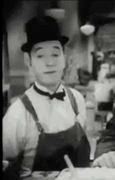 Charlie Chaplin tips his hat