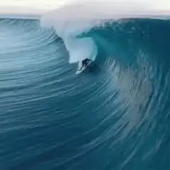 Surfer riding inside a massive wave barrel