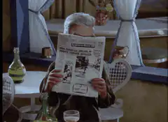 Man reading newspaper with glowing eyes