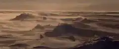 Wind blowing sand across desert dunes