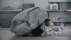 man crushed by giant rock in office