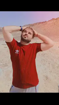 Man in red Adidas shirt with hands behind head
