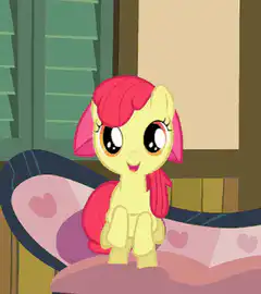 Apple Bloom sitting on a bed